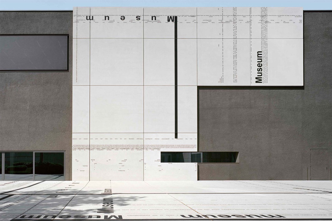 graue Sichtbetonfassade der Galerie Saarbrücken mit Textelementen von hemmerlein