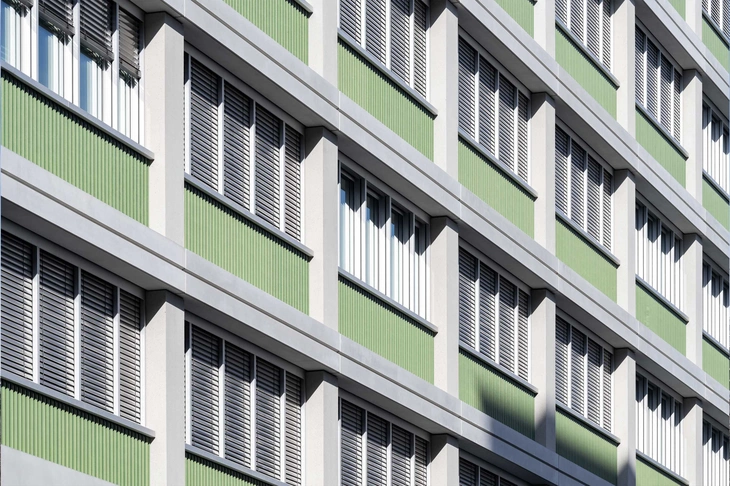 Sichtbetonfassade mit grüner Verkleidung am QH-Track Berlin