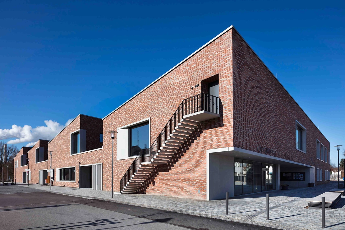 Fassade aus rotem Klinker und weißem Sichtbeton der Musikschule Unterföhring